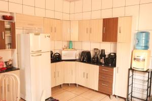 a kitchen with wooden cabinets and a white refrigerator at Casa de Temporada RA Olímpia in Olímpia
