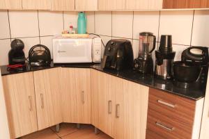 a kitchen counter with a microwave and appliances on it at Casa de Temporada RA Olímpia in Olímpia