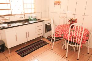 a kitchen with a table and a sink and a table and chairs at Casa de Temporada RA Olímpia in Olímpia +40 photos