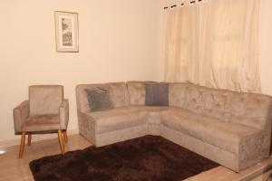 a living room with a couch and a chair at Casa de Temporada RA Olímpia in Olímpia