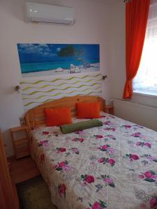 ハイドゥソボスローにあるRiviera Apartmanのベッドルーム1室(ピンクの花が咲くベッド1台付)