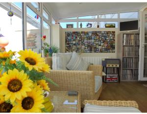 a living room with a couch and sunflowers at PennWay House - Two Bedroom House on Portland Bill with Sea Views! in Southwell