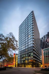 a tall building with many windows in a city at Cozy 1BR Apt - Downtown Winnipeg in Winnipeg