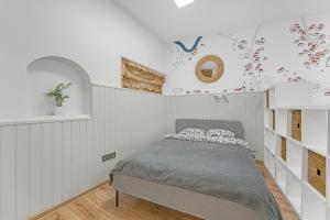 1 dormitorio con 1 cama en una habitación blanca en Vilnius Old Town apartment, en Vilna