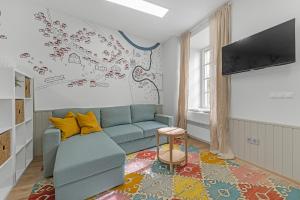 una sala de estar con un sofá azul y un mapa en la pared en Vilnius Old Town apartment, en Vilna
