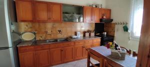 a kitchen with wooden cabinets and a sink at Alex house Thassos in Skala Sotiros +21 photos