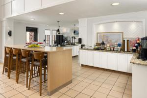 a kitchen with white cabinets and a island with bar stools at Staybridge Suites Minneapolis-Bloomington, an IHG Hotel in Bloomington