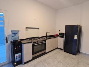 a kitchen with a stove and a refrigerator at Jimi Chalet in Al Kafrayn