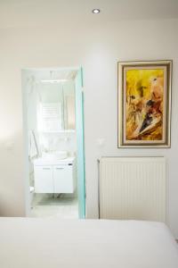 a bathroom with a sink and a painting on the wall at Keratea Luxury Villa -Athens Airport in Keratea