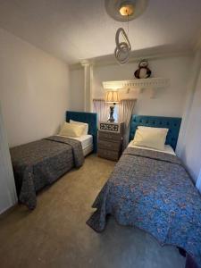 a bedroom with two beds and a table with a lamp at Beautiful & Cozy Newly remodeled 2 Bedroom in Amman