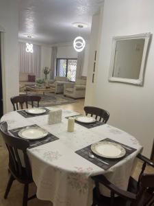 a dining room table with a white table cloth and chairs at Beautiful & Cozy Newly remodeled 2 Bedroom in Amman
