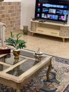 a living room with a coffee table and a tv at Beautiful & Cozy Newly remodeled 2 Bedroom in Amman