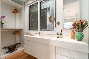 een badkamer met een witte wastafel en een raam bij Unhotel-Home Office Loft Vista para Lagoa in Rio de Janeiro