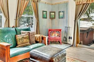 a living room with a green couch and a fireplace at Arapaho Forest Lodge w Hot Tub + Trail Access in Nederland