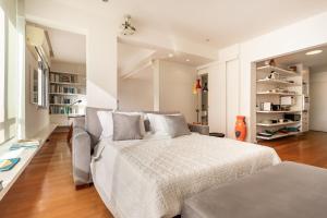 een witte slaapkamer met een bed en een bank bij Unhotel-Home Office Loft Vista para Lagoa in Rio de Janeiro