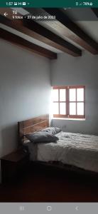 a bedroom with a bed and a window at Taita wasi in Cajamarca