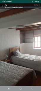 1 dormitorio con 2 camas y ventana en Taita wasi en Cajamarca