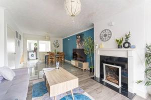 a living room with a table and a fireplace at Detached House with Free Parking, Fast Wifi, Smart TV and Garden by Yoko Property in Coventry