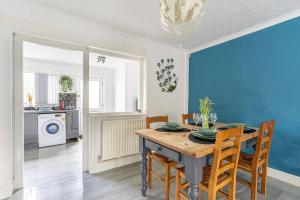 a dining room with a wooden table and chairs at Detached House with Free Parking, Fast Wifi, Smart TV and Garden by Yoko Property in Coventry