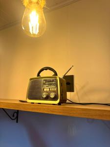 an old radio sitting on a shelf with a light at La vita hospedaria (quarto amarelo) in Nova Veneza