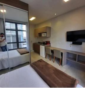 um quarto com uma cama, uma mesa e uma televisão em Pilon 427 em São Paulo