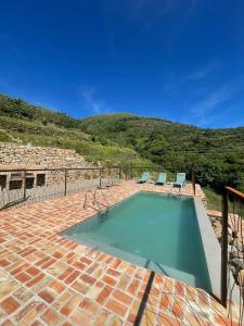 einen Pool mit zwei Stühlen in der Unterkunft Casa Rural La Garza y la Paloma in Navaconcejo