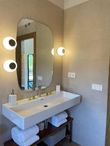 ein Bad mit einem Waschbecken, einem Spiegel und Handtüchern in der Unterkunft Casa Rural La Garza y la Paloma in Navaconcejo