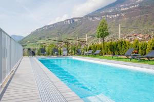 ein Schwimmbad mit Bergen im Hintergrund in der Unterkunft Quellenhof in Tramin an der Weinstraße