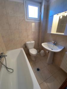 a bathroom with a tub and a toilet and a sink at Villa Marianna in Nea Vrasna