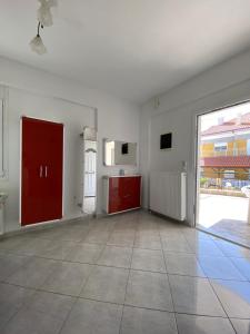 a kitchen with red cabinets and a large window at Villa Marianna in Nea Vrasna +42 photos