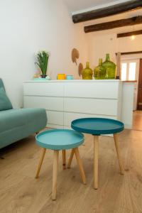 twee blauwe tafels in een woonkamer met een bank bij Loft - centre historique in Villefranche-sur-Mer