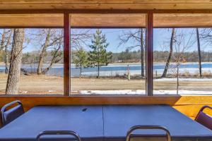- une table dans une chambre avec une grande fenêtre dans l'établissement Wooded Park Rapids Cabin Lake Access, Boat Slip!, à Arago