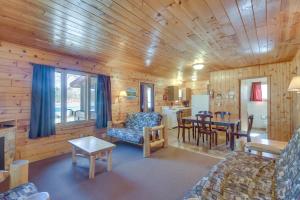 uma sala de estar com paredes de madeira e uma sala de jantar em Wooded Park Rapids Cabin Lake Access, Boat Slip! em Arago