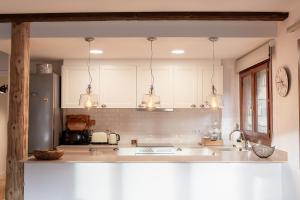 a kitchen with white cabinets and a counter top at Grandvalira Hogar Acogedor con Terraza y Parking I AndBnB in El Tarter