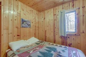 um quarto com uma cama numa parede de madeira em Wooded Park Rapids Cabin Lake Access, Boat Slip! em Arago