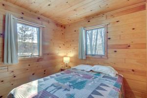 - une chambre avec un lit dans une cabane en bois dans l'établissement Serene Park Rapids Cabin Fire Pit, Lake Access!, à Arago