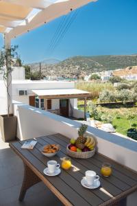 una mesa de madera con fruta en la parte superior de un balcón en Seacret House Sifnos, en Faros