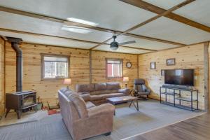 ein Wohnzimmer mit einem Sofa und einem TV in der Unterkunft Lakefront Cabin Getaway in Park Rapids Boat Dock! in Arago