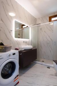 a bathroom with a washing machine and a sink at Seacret House Sifnos in Faros