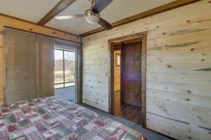 1 dormitorio con 1 cama y pared de madera en Lakefront Cabin Getaway in Park Rapids Boat Dock! en Arago