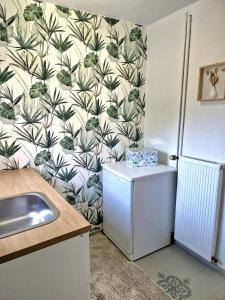 een keuken met behang met planten aan de muur bij Ferienhaus in Franken am Main in Kitzingen