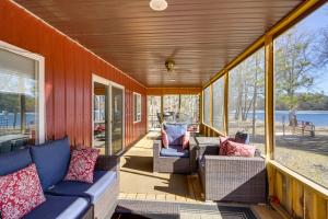 un porche cubierto con sofás y una mesa en Lakefront Cabin Getaway in Park Rapids Boat Dock! en Arago