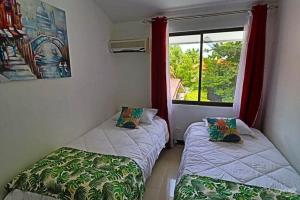 two beds in a room with a window at 2-BD Unit with Pool 2 Blocks from Beach in Coco