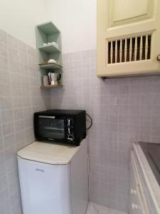 eine Mikrowelle auf einem WC in einer Küche in der Unterkunft Vacanze degli Sposi in Fregene
