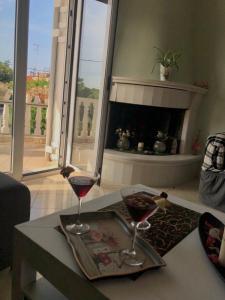 two glasses of red wine on a table in a living room at Villa Dani in Aigio