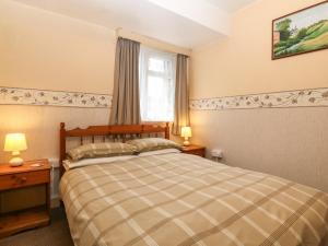 um quarto com uma cama e uma janela em First Floor Apartment em Porthmadog