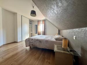 a bedroom with a bed and a wooden floor at Le manoir Obernois - 5mn du centre - 10 pers. in Obernai