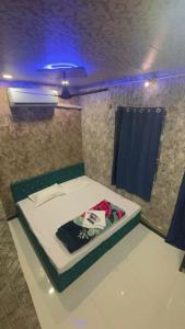 uma cama num quarto com uma luz azul em sun guest house 2 em Ujaim