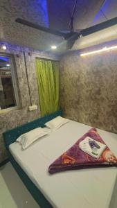 a bed in a small room with a green curtain at sun guest house 2 in Ujjain