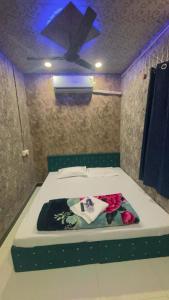 Cette chambre comprend un lit fleuri. dans l'établissement sun guest house 2, à Ujjain